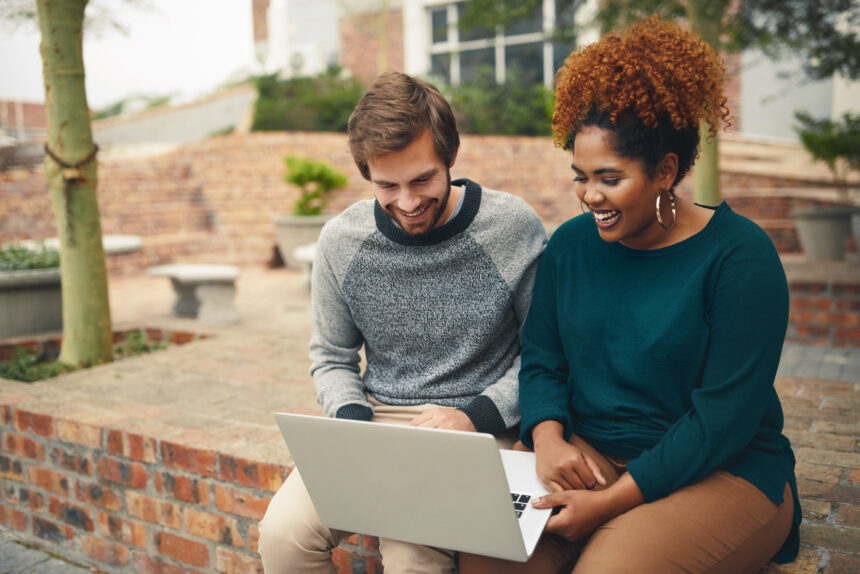 Two students working together on laptop